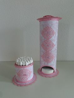 a pink and white toothbrush holder sitting on top of a table next to a brush