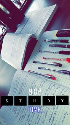 an open book sitting on top of a table next to writing utensils and pencils