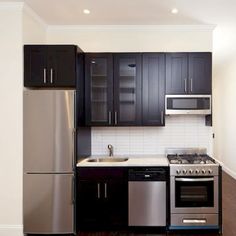 a kitchen with stainless steel appliances and black cabinets