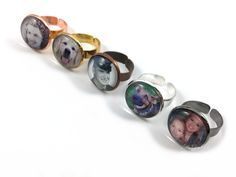 five different rings with pictures of people and dogs on them, all in different colors