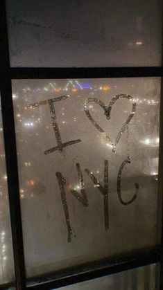 the words i love nyc written in frosted glass on a window sill at night