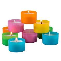 many different colored candles with one lit candle