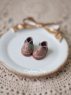 a pair of baby shoes sitting on top of a white plate