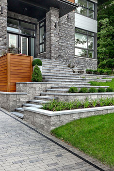 a house with stone steps leading up to the front door and landscaping area on either side