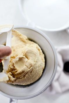 a person is scooping ice cream into a bowl