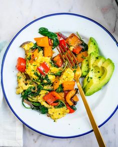 a white plate topped with eggs and vegetables