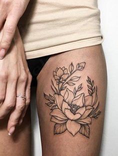 a woman's thigh with a flower tattoo on it