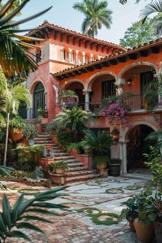 an orange house with lots of plants on the front and stairs leading up to it