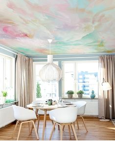 a dining room with painted ceilings and white chairs