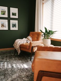 a living room with green walls and pictures on the wall, two couches and a chair