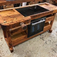 a wooden table with an oven built into it's sides in a workshop area