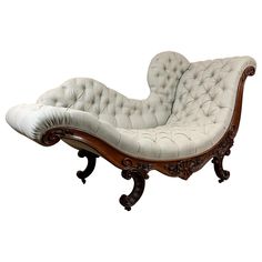 an old fashioned chaise lounge chair with white upholstered fabric