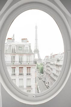 a round window with the eiffel tower in the background