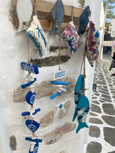 some blue and white items hanging on a wall next to a stone walkway with cobblestone flooring