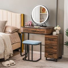 a bedroom with a bed, mirror and stool in the corner next to a dresser