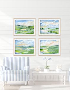 three paintings hang on the wall above a couch in a room with white walls and striped furniture