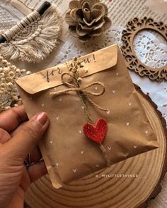 someone is holding a brown paper bag with a red heart on it and some other decorations