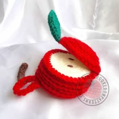 a crocheted apple sitting on top of a white sheet