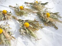 some yellow flowers and grass on a white table cloth