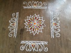 some white and red designs on a wooden floor in the shape of a sunflower