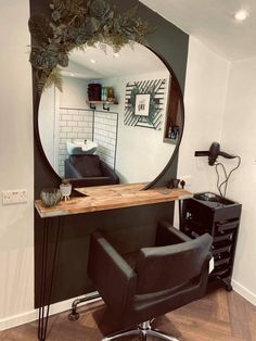 a mirror sitting on top of a wooden table next to a black chair and desk