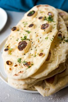 a white plate topped with flat bread on top of a table