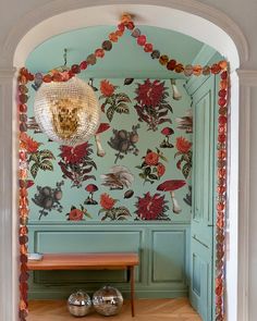 a room with green walls and floral wallpaper on the walls, along with a wooden bench