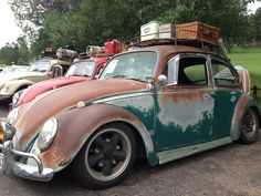 an old vw bug with luggage strapped to the roof is parked in a lot