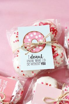 pink and white donuts wrapped in cellophane with tags on them for valentine's day