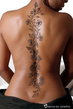 the back of a woman's body with tattoos on it