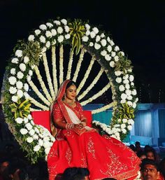 a woman sitting on top of a giant wheel in front of a group of people