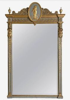 an ornate gold framed mirror with a statue on the top and bottom half of it