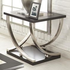 a black and silver end table in front of a window with a picture frame on it