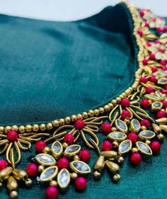 the necklace is adorned with red stones and gold beads