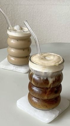 two jars filled with food sitting on top of a white table next to each other