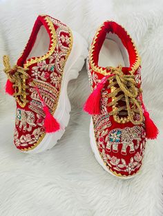 a pair of red and gold shoes with white soles