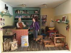 two dolls are standing in a doll house