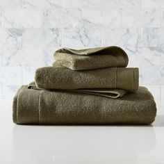 towels stacked on top of each other in front of a marble wall