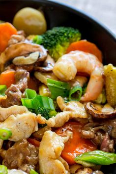 a skillet filled with stir fry vegetables and meat