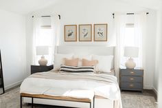 a bed with white sheets and pillows in a bedroom