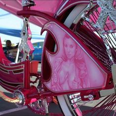 a close up of a pink bike with a woman on it