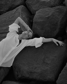 black and white photograph of woman laying on rocks