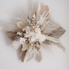 an arrangement of flowers and feathers on a white background