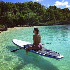 a woman sitting on top of a surfboard in the ocean