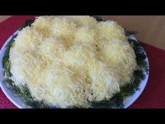 a cheese covered cake sitting on top of a white plate next to a red table cloth