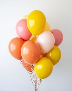 a bunch of balloons that are on top of each other in front of a white wall