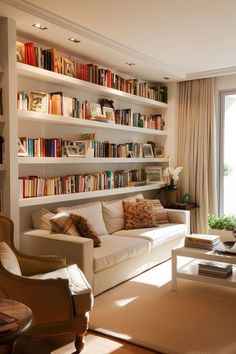 a living room filled with lots of furniture and bookshelves full of books on the wall