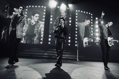 the jonas brothers performing on stage in black and white