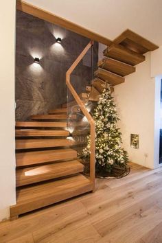 a wooden stair case next to a christmas tree