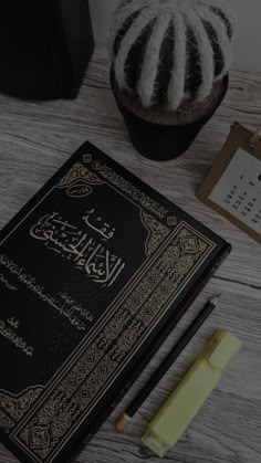 an open book sitting on top of a wooden table next to a pen and pencil